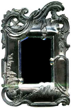 A beside Mirror. with an elaborate aperture. The glass has been cut and bevelled to match.