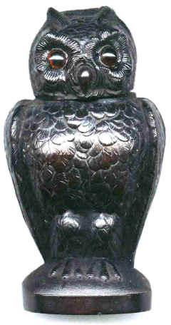 An Owl. The head hinges back to reveal a recess to hold either matches or an inkwell. The eyes are made of glass.