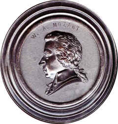 Mounted within a turned wooden collar. Back stippled with no markings. Engravers mark is a short twisted bar.